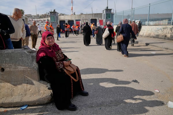 An elderly Palestinian woman rests after she was not allowed to cross from the Israeli military Qalandia checkpoint near the West Bank city of Ramallah to Jerusalem, to participate in the Friday prayers at the Al-Aqsa Mosque compound during the Muslim holy month of Ramadan on Friday, March 14, 2025. (AP Photo/Nasser Nasser)