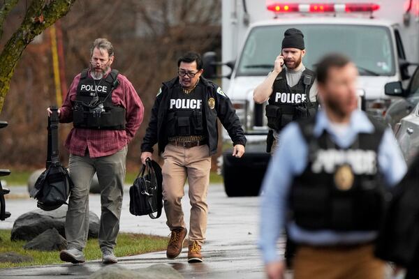 Police walk outside the Abundant Life Christian School following a shooting, Monday, Dec. 16, 2024 in Madison, Wis. (AP Photo/Morry Gash)