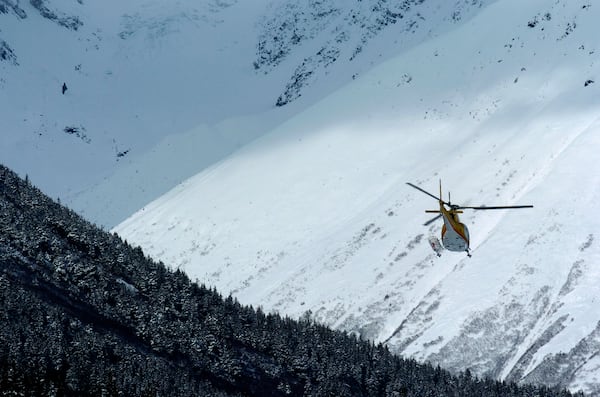 This March 29, 2005, photo shows a helicopter transporting skiers back to Girdwood, Alaska, at the end of a day of heli-skiing. (Marc Lester/Anchorage Daily News via AP)