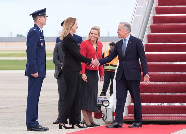 Canada's Prime Minister Mark Carney, right, is greeted by Canadian Ambassador to the U.S. Kirsten Hillman, second left, U.S. Acting Chief of Protocol Abby Jones, and U.S. Col. Randall J. Heusser after he disembarks a government plane Monday, May 5, 2025, as he arrives in Washington. (Adrian Wyld/The Canadian Press via AP)