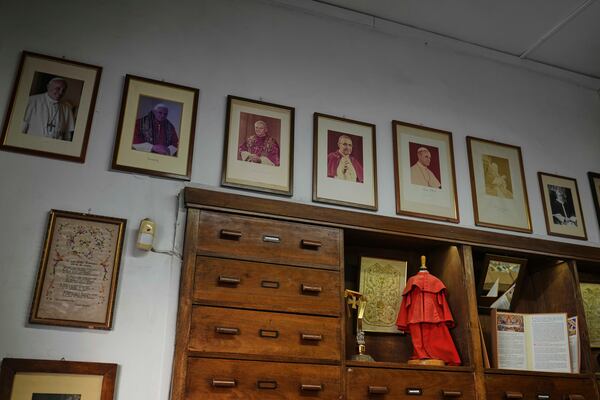 Portraits of late Popes hang at the Gammarelli ecclesiastic clothes tailor shop in Rome, Wednesday, April 30, 2025. (AP Photo/Francisco Seco)