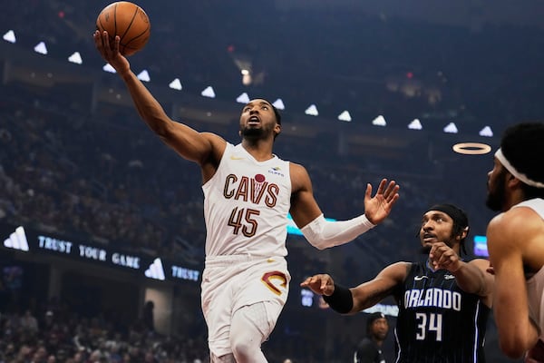 Cleveland Cavaliers guard Donovan Mitchell (45) goes to the basket past Orlando Magic center Wendell Carter Jr. (34) in the first half of an NBA basketball game Sunday, March 16, 2025, in Cleveland. (AP Photo/Sue Ogrocki)