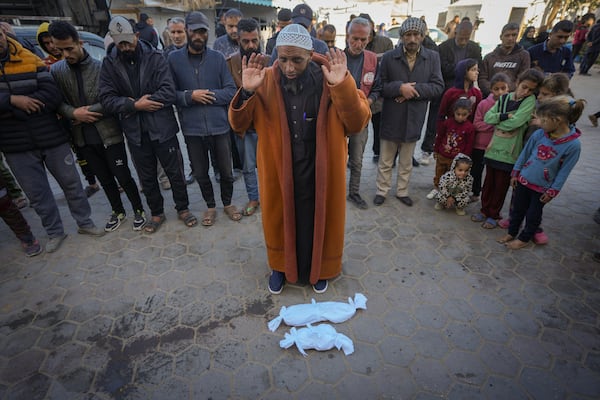 Imam Islam Abu Suaied prays over the bodies of two babies before their burial at the Al-Aqsa Martyrs Hospital in Deir al-Balah, central Gaza Strip, Sunday, Dec. 29, 2024. One baby died at birth, while the other, 20-day-old Jomaa al-Batran, succumbed to hypothermia. According to local health officials, at least three other babies in Gaza have died from the cold in recent weeks.(AP Photo/Abdel Kareem Hana)