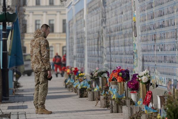 A serviceman mourns at the Memorial Wall of Fallen Defenders of Ukraine in Russian-Ukrainian War in Kyiv, Ukraine, Monday, Feb. 24, 2025. (AP Photo/Andrew Kravchenko)