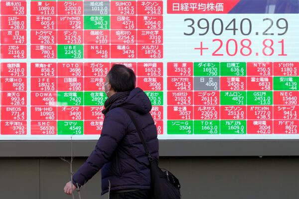 A person looks at an electronic stock board showing Japan's Nikkei index, right top, at a securities firm Thursday, Feb. 6, 2025, in Tokyo. (AP Photo/Eugene Hoshiko)