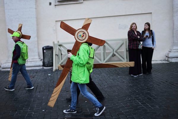 Volunteers carry wooden crosses in St. Peter's Square at the Vatican, Tuesday, March 11, 2025. (AP Photo/Francisco Seco)