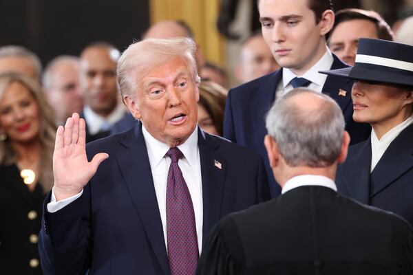 President-elect Donald Trump, from left, takes the oath of office as Barron Trump and Melania Trump watch at the 60th Presidential Inauguration in the Rotunda of the U.S. Capitol in Washington, Monday, Jan. 20, 2025. (Kevin Lamarque/Pool Photo via AP)