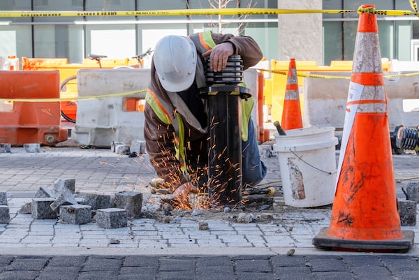 A worker removes a traffic bollard along the Black Lives Matter mural, Monday, March 10, 2025, in Washington. (AP Photo/Jacquelyn Martin)