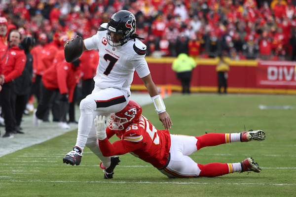 Houston Texans quarterback C.J. Stroud (7) runs with the ball as Kansas City Chiefs defensive end George Karlaftis defends during the first half of an NFL football AFC divisional playoff game Saturday, Jan. 18, 2025, in Kansas City, Mo. (AP Photo/Travis Heying)