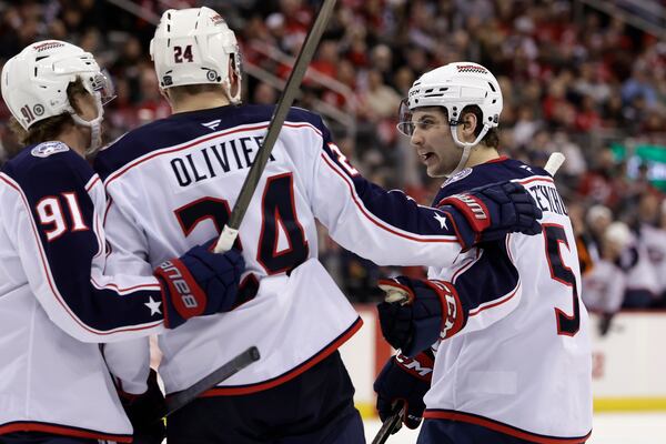 Columbus Blue Jackets right wing Mathieu Olivier (24) is congratulated by Denton Mateychuk (5) and Kent Johnson (91) after scoring a goal in the third period of an NHL hockey game Tuesday, March 11, 2025, in Newark, N.J. (AP Photo/Adam Hunger)