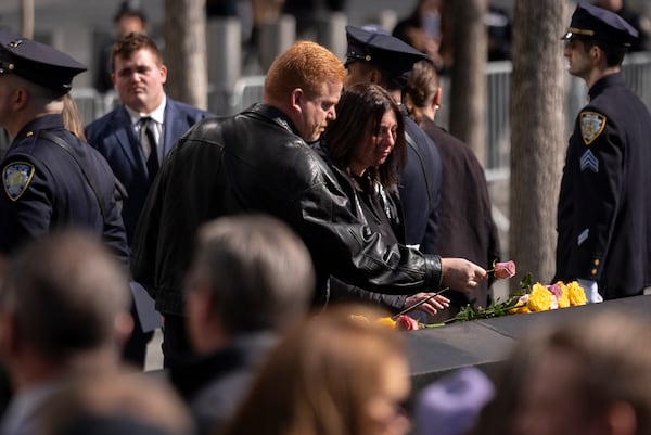 Family members of the deceased place flowers on the names of their relatives during a ceremony marking the anniversary of the 1993 World Trade Center bombing at the 9/11 Memorial, Wednesday, Feb. 26, 2025, in New York. (AP Photo/John Minchillo)