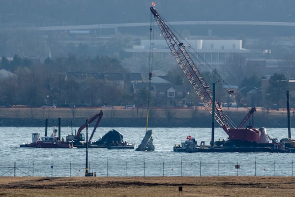 A piece of wreckage is lifted from the water onto a salvage vessel near the site in the Potomac River of a mid-air collision between an American Airlines jet and a Black Hawk helicopter, at Ronald Reagan Washington National Airport, Tuesday, Feb. 4, 2025, in Arlington, Va. (AP Photo/Ben Curtis)