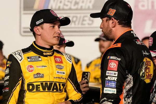 Christopher Bell, left, speaks with Chase Briscoe after bell won the race after a NASCAR Cup Series auto race, Sunday, Feb. 23, 2025, in Hampton, Ga. (AP Photo/Mike Stewart)