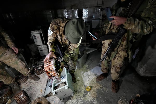 A Syrian member of the rebel group unloads amphetamine pills, known as Captagon, hidden inside an electrical component at the warehouse where the drug was manufactured before the fall of Bashar Assad government at a facility in Douma city, outskirts of Damascus, Syria, Friday, Dec. 13, 2024. (AP Photo/Hussein Malla)