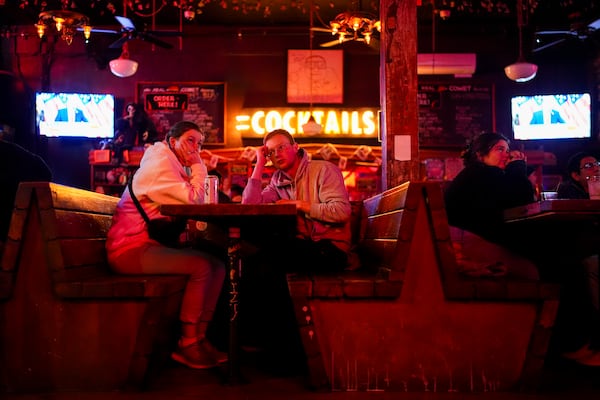 FILE - People watch as television screens show Republican presidential nominee former President Donald Trump addressing supporters on Election Day, Tuesday, Nov. 5, 2024, at Comet Tavern in Seattle. (AP Photo/Lindsey Wasson, File)