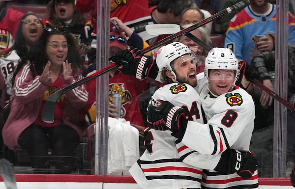 Chicago Blackhawks left wing Landon Slaggert, left, celebrates with center Ryan Donato (8) after scoring a goal during the first period of an NHL hockey game against the Florida Panthers, Saturday, Feb. 1, 2025, in Sunrise, Fla. (AP Photo/Lynne Sladky)