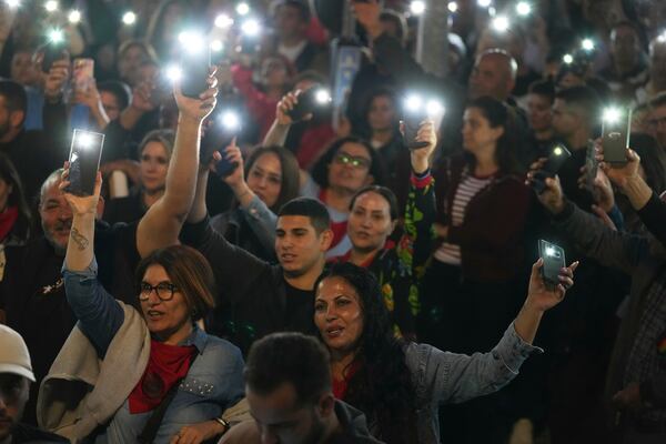 Turkish Cypriot protesters hold the lighted mobile phones aloft as they gather to protest against what they say is Turkey's attempt to erode their secular roots and to strengthen the hold of political Islam over their society, in the northern half of ethnically divided Cyprus' capital Nicosia, on Friday, May 2, 2025. (AP Photo/Petros Karadjias)