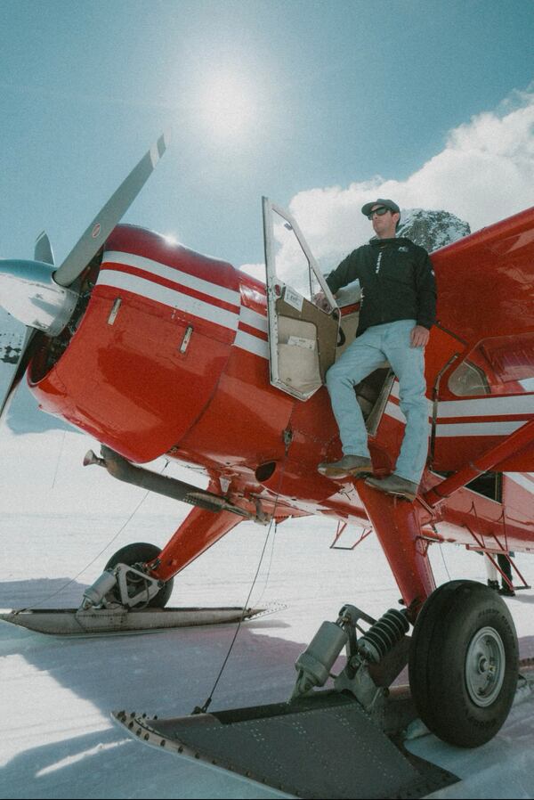 In this photo provided by Andrew Esola, Joe McAneney stands on his plane in the Ruth Amphitheater on Mount McKinley, Alaska, May 25, 2024. (Andrew Esola via AP)