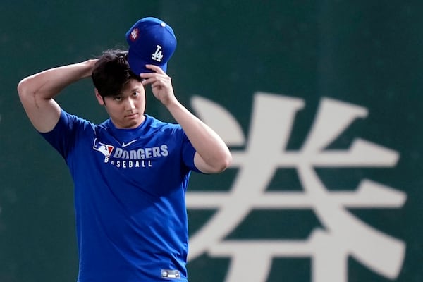 Los Angeles Dodgers two-way player Shohei Ohtani warms up during the official training, Friday, March 14, 2025, in Tokyo, ahead of the start of the MLB Tokyo Series at the Tokyo Dome. (AP Photo/Eugene Hoshiko)