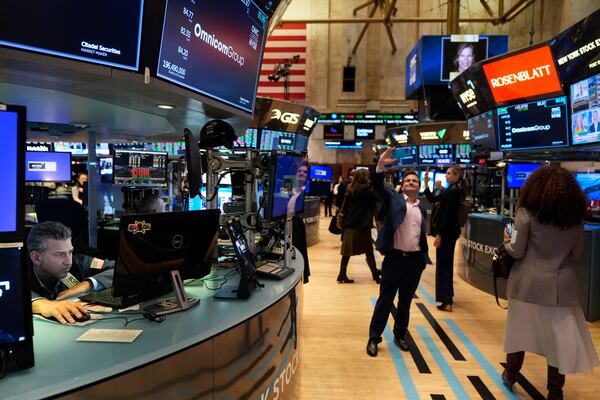 People take pictures while others work on the floor at the New York Stock Exchange in New York, Monday, Feb. 24, 2025. (AP Photo/Seth Wenig)