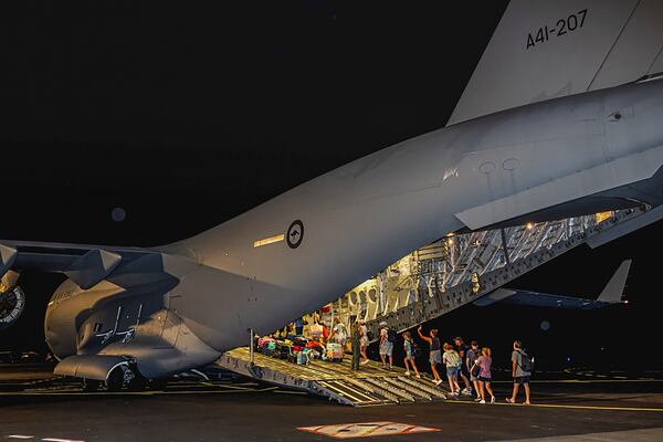 In this photo released by Australian Department of Defence, Australian citizens board a Royal Australian Air Force aircraft for a flight home from Bauerfield International Airport, Port Vila, Vanuatu, Wednesday, Dec. 18, 2024 following a powerful earthquake that struck just off the coast of Vanuatu in the South Pacific Ocean. (CPL Adam Abela/Australian Department of Defence via AP)