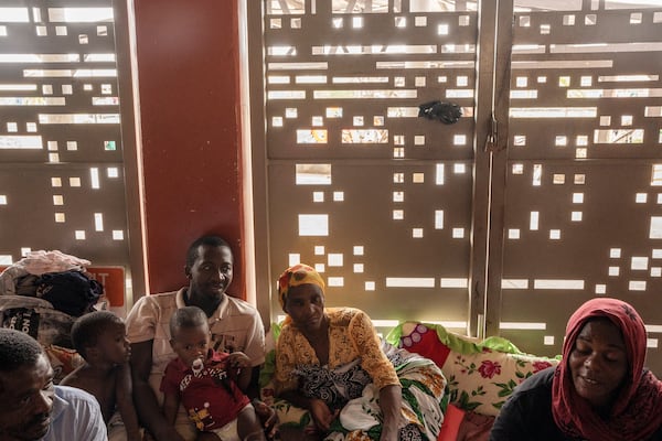 Mohamed Ankidine, 28, third left, with feet injuries, Saindou Dahabou who suffers from diabetes, and Alibouna Haithouna, 33, find refuge at the Lycée des Lumières after losing their homes, in Mamoudzou, Mayotte, Thursday, Dec. 19, 2024. (AP Photo/Adrienne Surprenant)