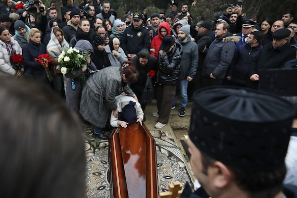 Yana Kshnyakina, widow of pilot in command Igor Kshnyakin mourns during a funeral of crew members of the Azerbaijan Airlines Embraer 190 killed in a deadly plane crash in Kazakhstan this week, at the II Alley of Honor in Baku, Azerbaijan, Sunday, Dec. 29, 2024. (AP photo)