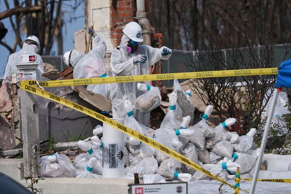Cal/OSHA workers remove hazardous materials from a home destroyed by the Palisades Fire in the Pacific Palisades neighborhood of Los Angeles, Thursday, April 24, 2025. (AP Photo/Damian Dovarganes)