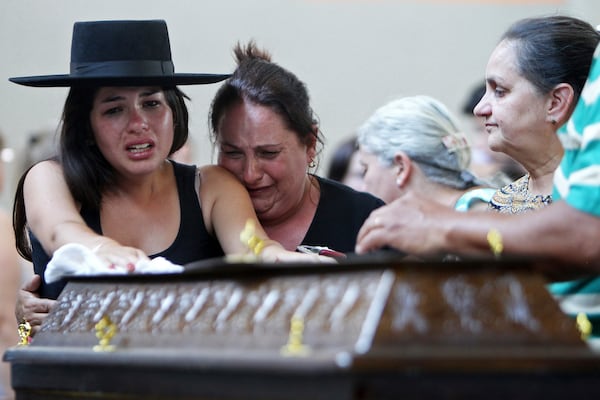 FILE - Relatives cry next to a coffin at a gymnasium where bodies were brought for identification in Santa Maria city, Rio Grande do Sul state, Brazil, Sunday, Jan. 27, 2013 (AP Photo/Nabor Goulart, File)