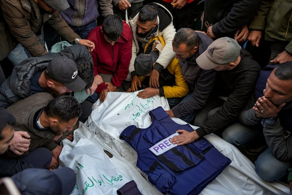 Relatives and friends mourn over the bodies of five Palestinian journalists who were killed by an Israeli airstrike in Gaza City at the Al-Aqsa Hospital in Deir al-Balah, Thursday, Dec. 26, 2024. (AP Photo/Abdel Kareem Hana)