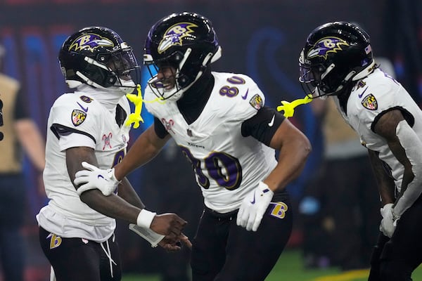 Baltimore Ravens quarterback Lamar Jackson, left, celebrates with teammates after a 48-yard touchdown run during the second half of an NFL football game against the Houston Texans, Wednesday, Dec. 25, 2024, in Houston. (AP Photo/David J. Phillip)