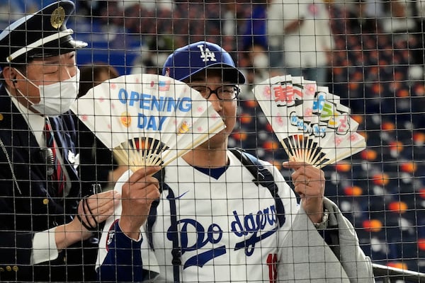 A fan watches warmups before an MLB Japan Series baseball game between the Los Angeles Dodgers and Chicago Cubs in Tokyo, Japan, Tuesday, March 18, 2025. (AP Photo/Eugene Hoshiko)