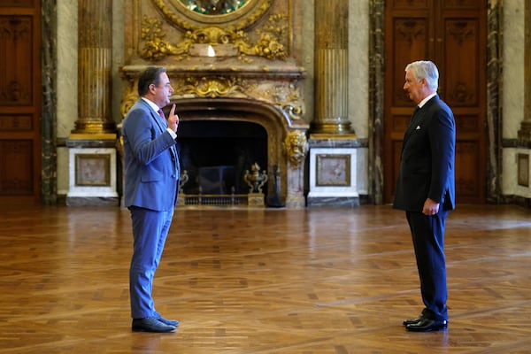 New Belgian Prime Minister Bart De Wever, left, raises his hand to take an oath during a swearing in ceremony for the new government in front of Belgium's King Philippe at the Royal Palace in Brussels, Monday, Feb. 3, 2025. (AP Photo/Omar Havana)