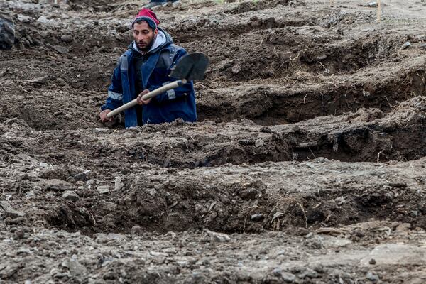 A worker digs graves for the victims of a massive nightclub fire in the town of Kocani, North Macedonia, Tuesday, March 18, 2025. (AP Photo/Visar Kryeziu)