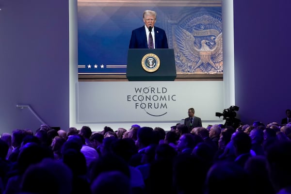 Attendees listen to a virtual speech delivered by U.S. president Donald Trump, at the Annual Meeting of World Economic Forum in Davos, Switzerland, Thursday, Jan. 23, 2025. (AP Photo/Markus Schreiber)