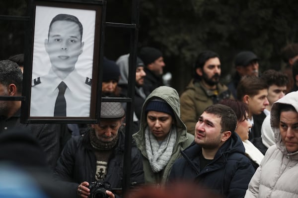 People mourn at the grave of First Officer Aleksandr Kalyaninov during a funeral of the crew members of the Azerbaijan Airlines Embraer 190 killed in a deadly plane crash in Kazakhstan this week, at the II Alley of Honor in Baku, Azerbaijan, Sunday, Dec. 29, 2024. (AP photo)