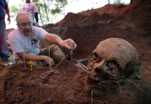 FILE - Rogelio Goiburu, a member of Paraguay's Truth and Justice Commission, looks at skeletal remains found buried as they are excavated at the National Police Special Forces headquarters in Asuncion, Paraguay, March 19, 2013. Goiburu's father, an opponent of the Stroessner dictatorship, went missing in 1977. (AP Photo/Jorge Saenz, File)