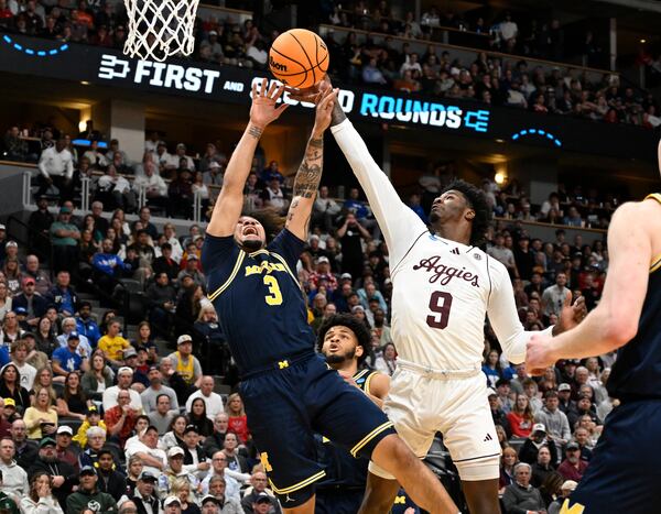 Texas A&M forward Solomon Washington, right, blocks a shot by Michigan guard Tre Donaldson during the first half in the second round of the NCAA college basketball tournament Saturday, March 22, 2025, in Denver. (AP Photo/John Leyba)