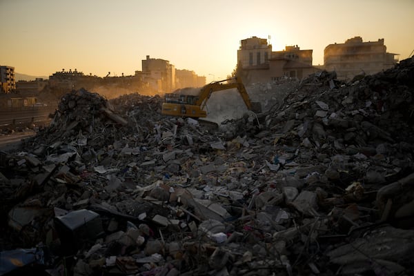 FILE - An excavator digs in the rubble of destroyed buildings in Iskenderun city, southern Turkey, Tuesday, Feb. 14, 2023. (AP Photo/Francisco Seco, File)