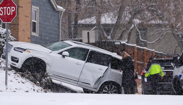 Motorists survey damage done to a utility vehicle in a crash at an intersection as a winter storm sweeps over the intermountain West and across the country Tuesday, Jan. 7, 2025, in southeast Denver. (AP Photo/David Zalubowski)