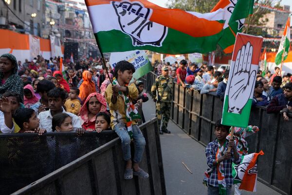 Children hold the Congress party flag during Delhi Assembly elections campaign rally in Delhi, India, Thursday, Jan. 30, 2025. (AP Photo/Channi Anand)