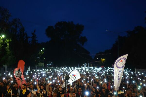 Turkish Cypriot protesters hold the lighted mobile phones aloft as they gather to protest against what they say is Turkey's attempt to erode their secular roots and to strengthen the hold of political Islam over their society, in the northern half of ethnically divided Cyprus' capital Nicosia, on Friday, May 2, 2025. (AP Photo/Petros Karadjias)