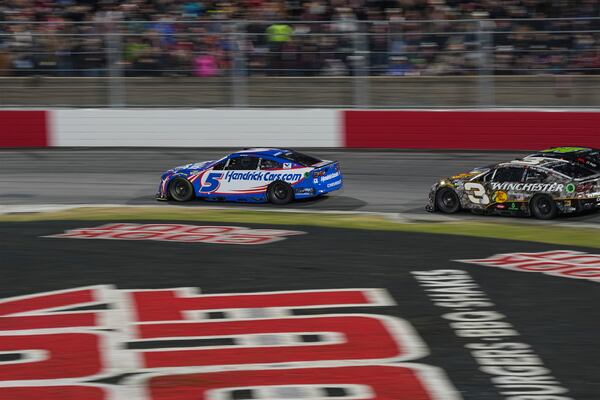 Kyle Larson (5) and Austin Dillon (3) compete through Turn 2 in a qualifying heat during a NASCAR Cup Series auto race at Bowman Gray Stadium, Sunday, Feb. 2, 2025, in Winston-Salem, N.C. (AP Photo/Matt Kelley)