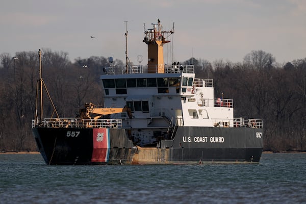 A Coast Guard vessel works on the Potomac river, Saturday, Feb. 1, 2025, in Arlington, Va., near the wreckage site where an American Airlines jet and a Black Hawk helicopter collided, as seen from Alexandria, Va. (AP Photo/Carolyn Kaster)