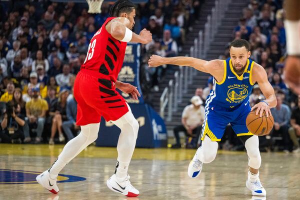 Golden State Warriors guard Stephen Curry (30) drives the ball past Portland Trail Blazers forward Toumani Camara, left, during the first half of an NBA basketball game in San Francisco, Monday, March 10, 2025. (AP Photo/Nic Coury)