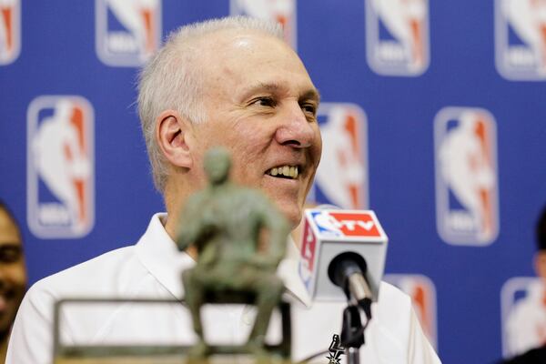 FILE - San Antonio Spurs coach Gregg Popovich sits with the Red Auerbach trophy during an NBA basketball news conference after he was named the coach of the year, Tuesday, April 22, 2014, in San Antonio. (AP Photo/Eric Gay, File)