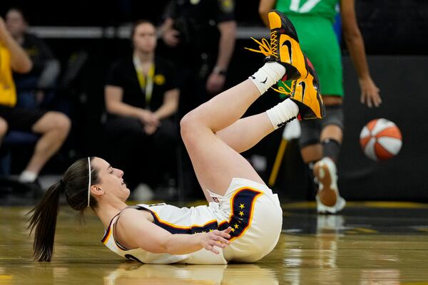 Indiana Fever guard Caitlin Clark falls after making a 3e-point basket during the first half of an exhibition women's basketball game against Brazil, Sunday, May 4, 2025, in Iowa City, Iowa. (AP Photo/Charlie Neibergall)