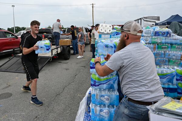 Volunteers deliver water to a command center at the London-Corbin Airport in London, Ky., Monday, May 19, 2025. (AP Photo/Timothy D. Easley)