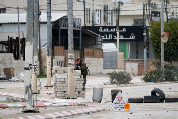 An Israeli soldier aims his weapon during a military raid in the West Bank refugee camp of Nur Shams, Tulkarem, Sunday, Feb. 9, 2025. (AP Photo/Majdi Mohammed)