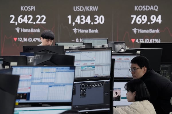 Currency traders watch monitors near a screen showing the Korea Composite Stock Price Index (KOSPI), top left, and the foreign exchange rate between U.S. dollar and South Korean won, top center, at the foreign exchange dealing room of the KEB Hana Bank headquarters in Seoul, South Korea, Monday, Feb. 24, 2025. (AP Photo/Ahn Young-joon)